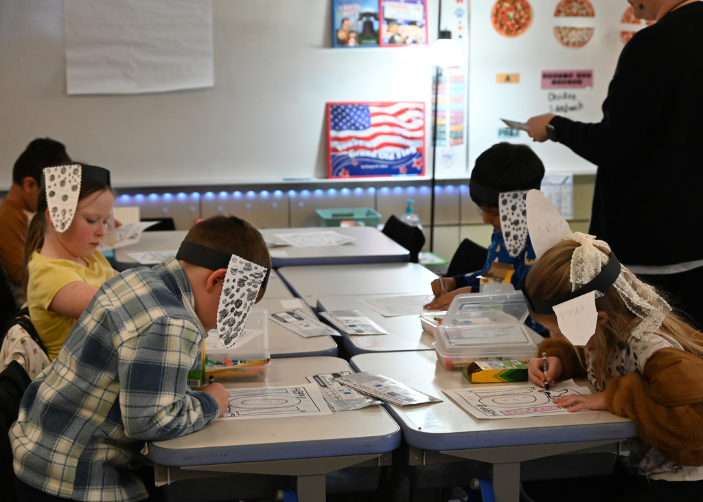 4 kids at deske writing while wearing dalmation ears