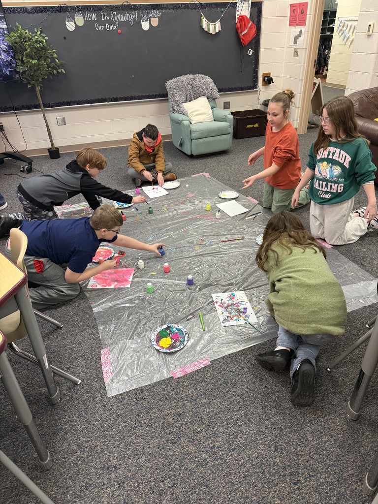 6 students in circle on floor painting