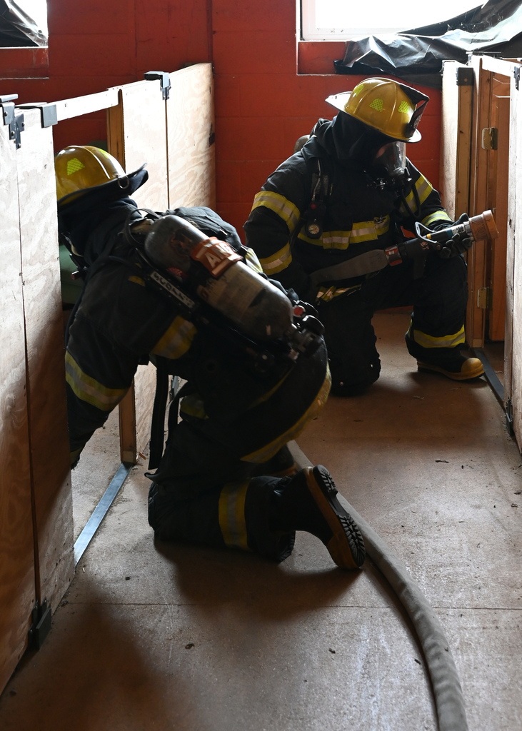 two fire fighters on knees with hoses