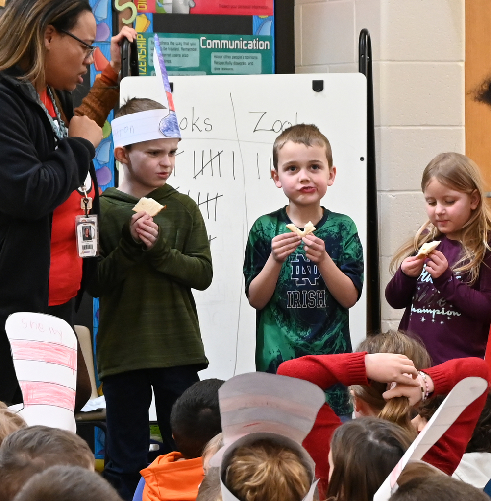 teacher and three students reacting to taking a bite of food