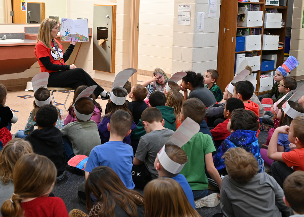 teacher reading to class of students