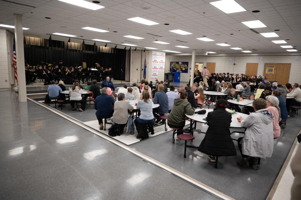 cafeteria filled with people watching a middle school band competition