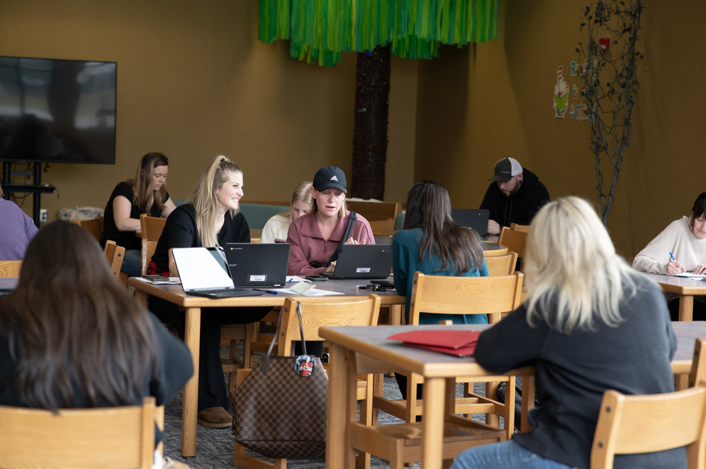 room of adults at tables working on computers
