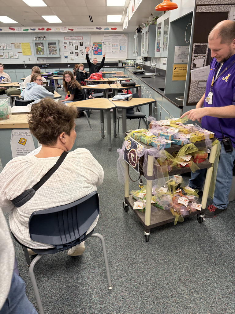 a man with a cart of pies in a classroom