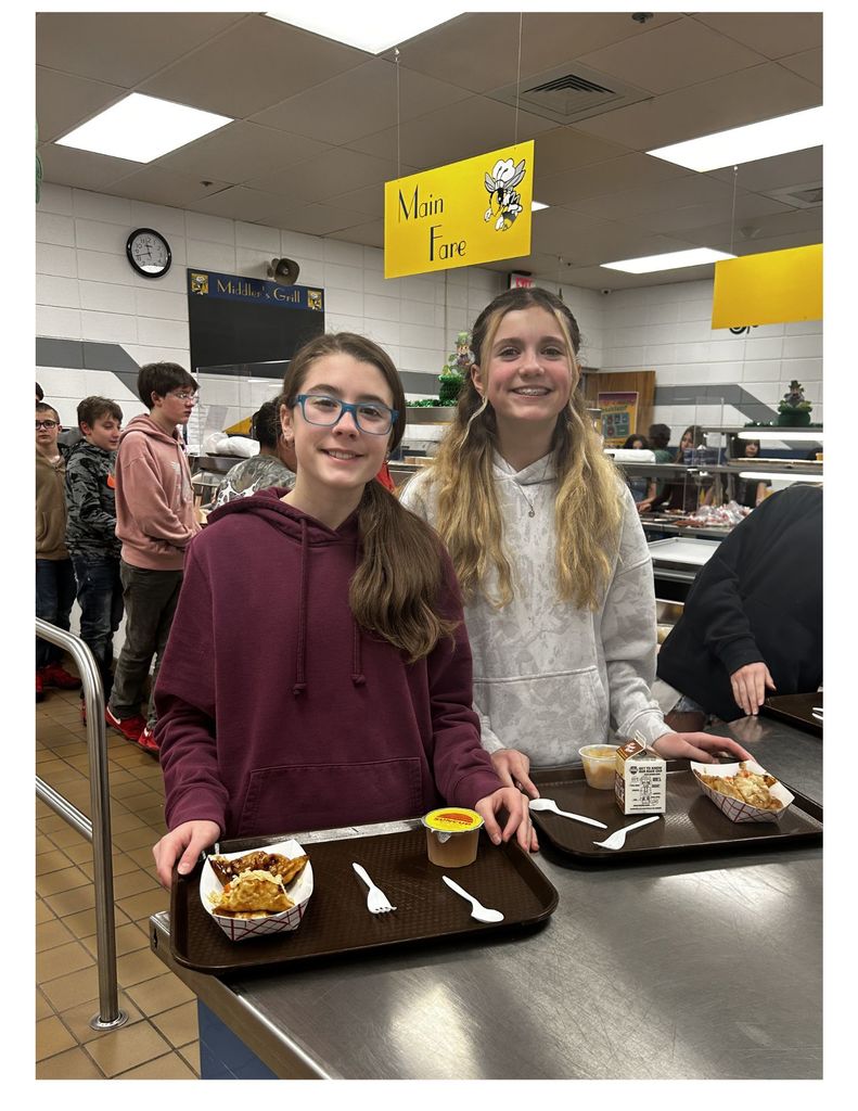 2 girls with trays getting lunch in a cafeteria