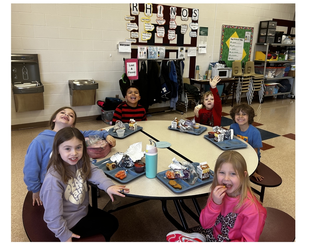 Children sitting around a cafeteria table eating lunch