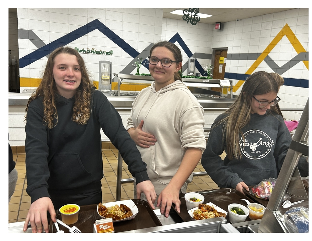 3 girls in line with trays getting food in cafeteria