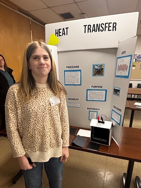 girl standing in front of poster display for science fair