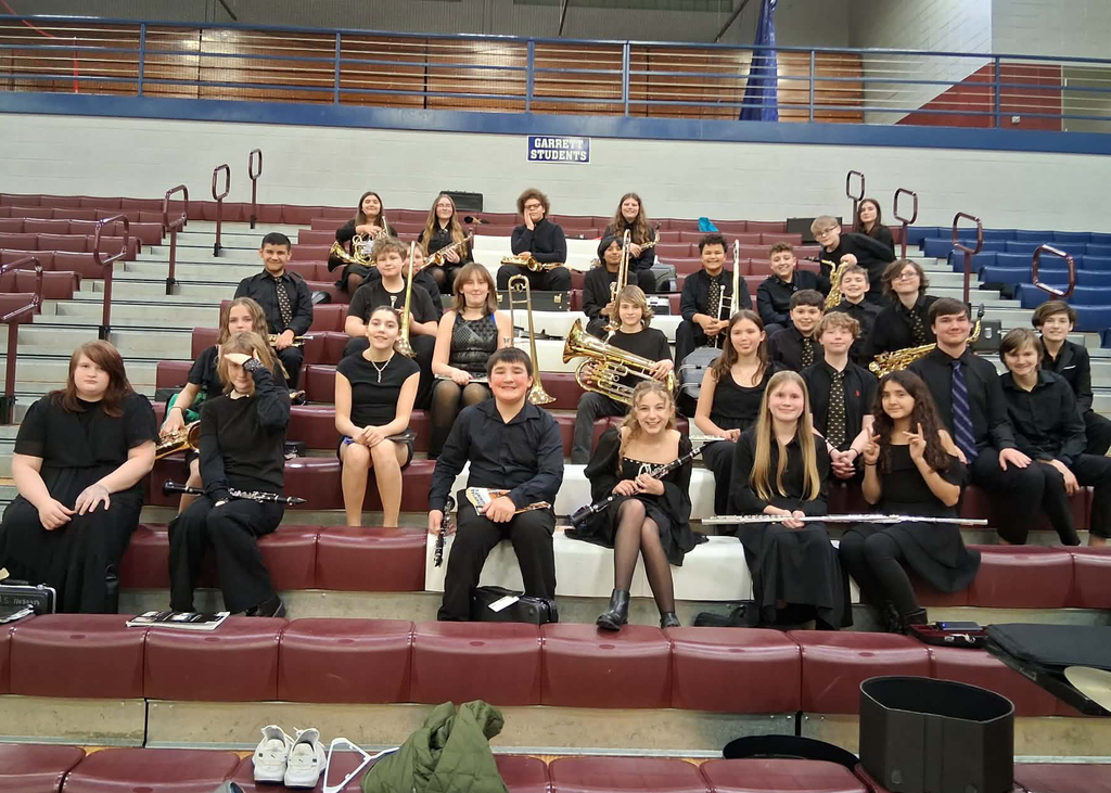 students holding instruments on bleachers