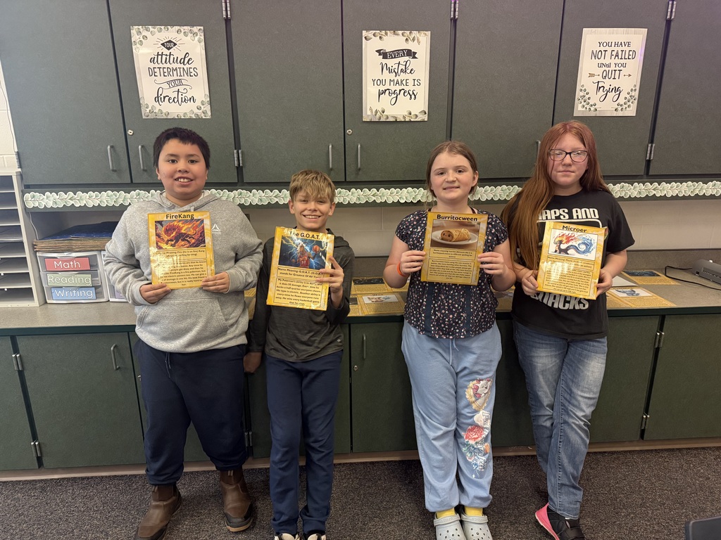 four fifth grade students holding self made pokemon cards