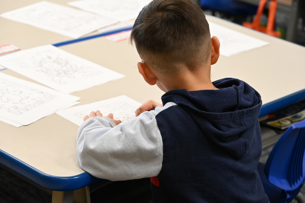 child drawing at desk