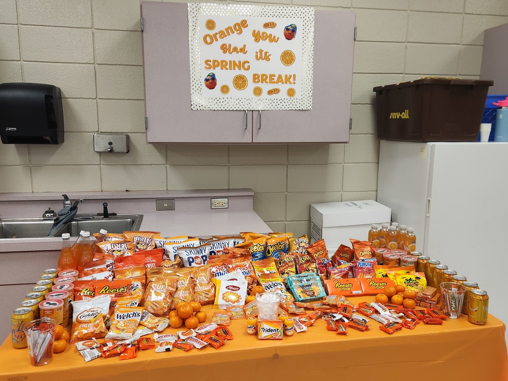 a table filled with snacks and drinks all in packages colored orange with a sign that says orange you glad its spring break