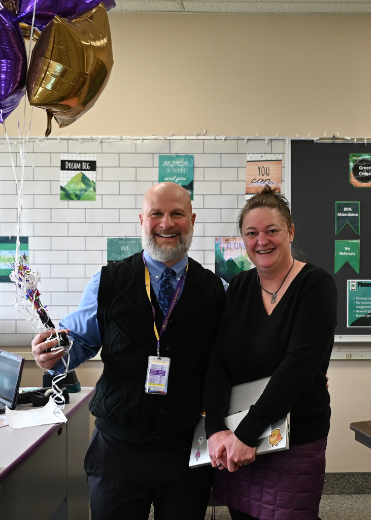 two people standing together posing for picture