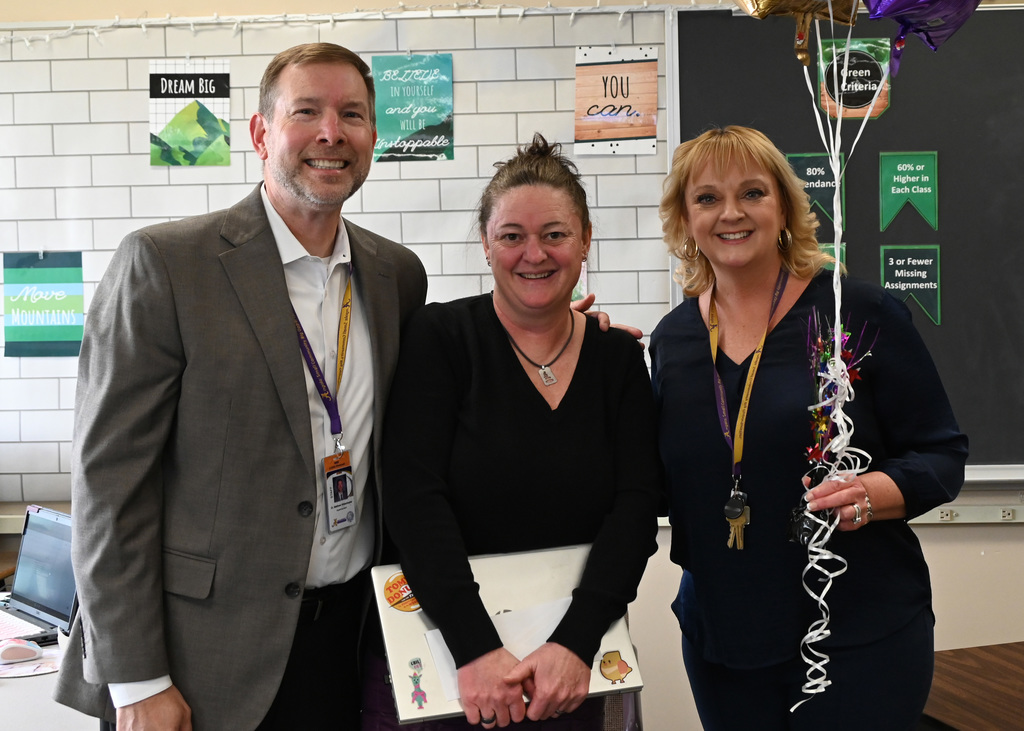 3 people standing in line posing for picture