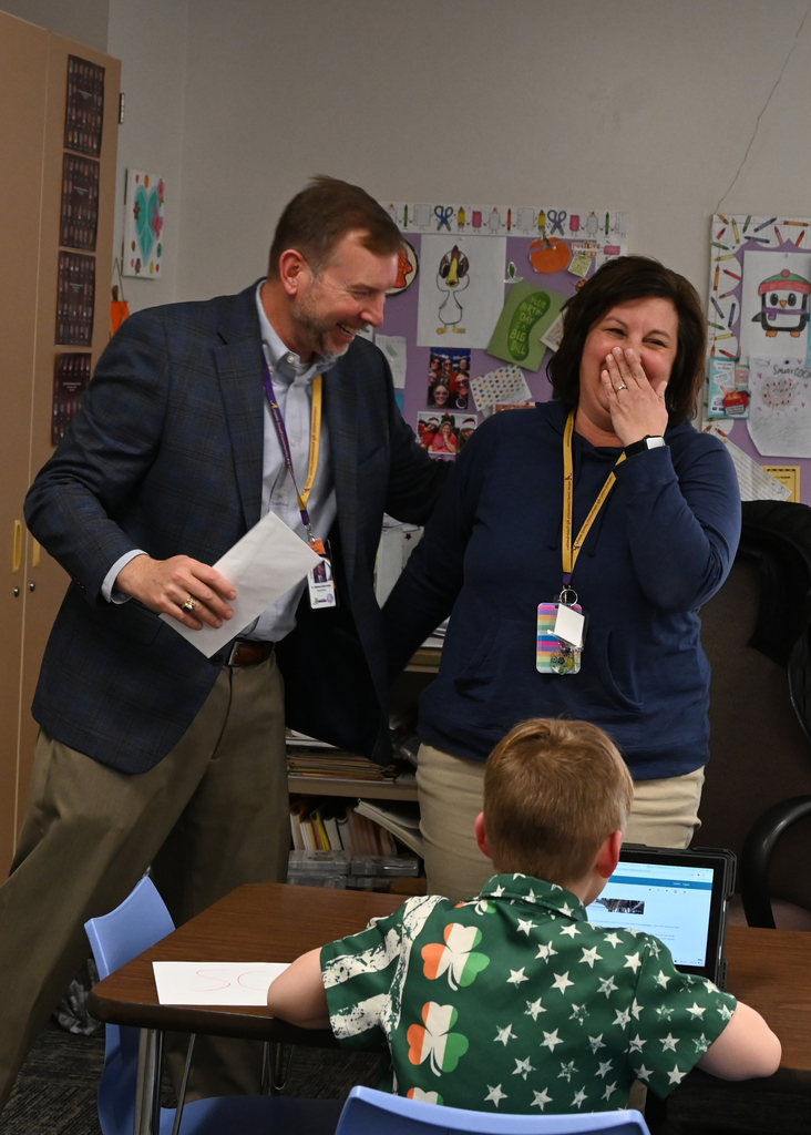woman covering mouth in surprise as another pats her on the back