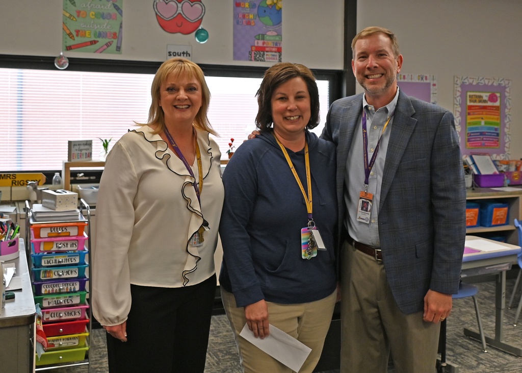 three people standing in line smiling