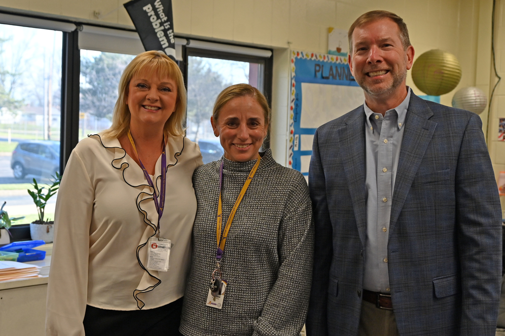 three adulst smiling standing in ling