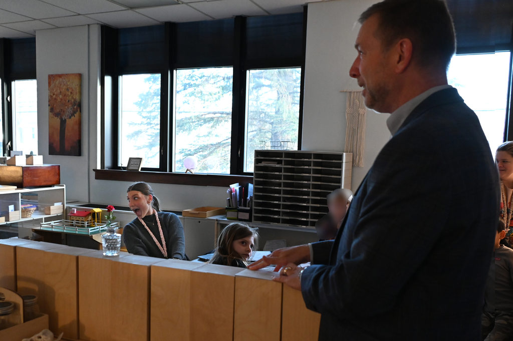 woman and table suprised as man stand talking to her