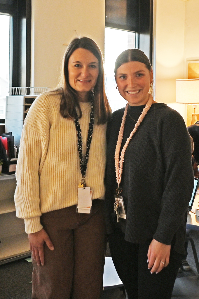 two women standing side by side smiling