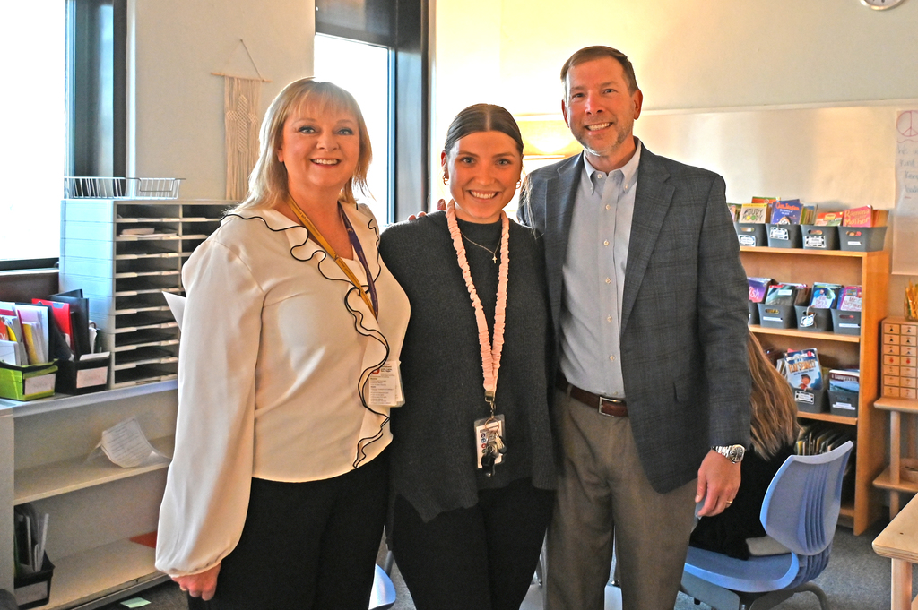 three people standing in line smiling