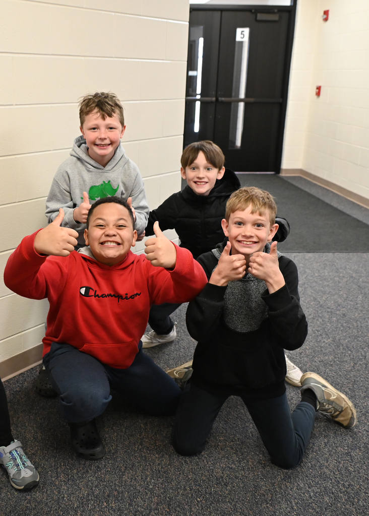 4 boys with thumbs up posing for the camera