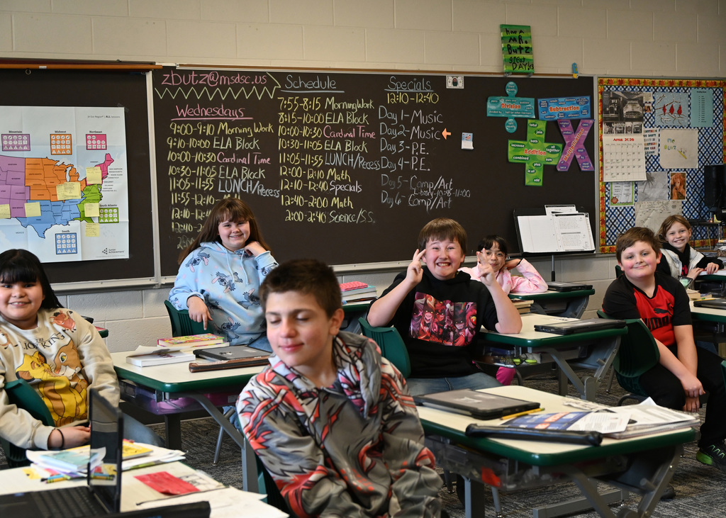 students in a classroom smiling