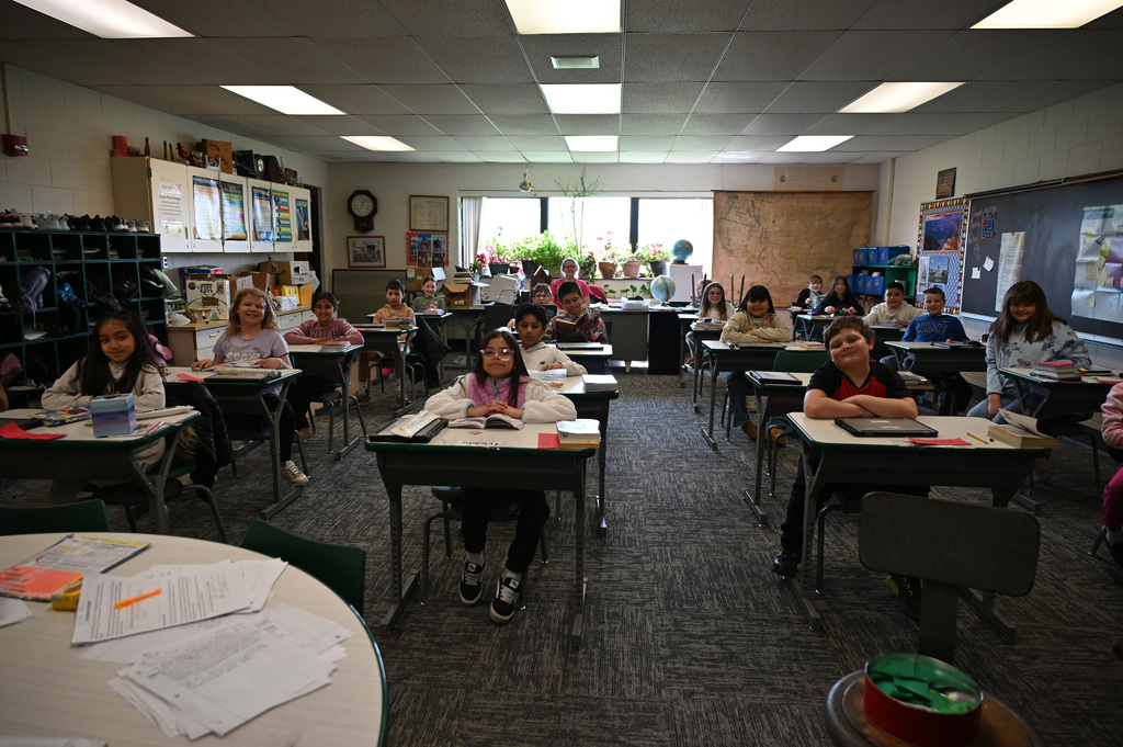 Classroom of students sitting at desks smiling