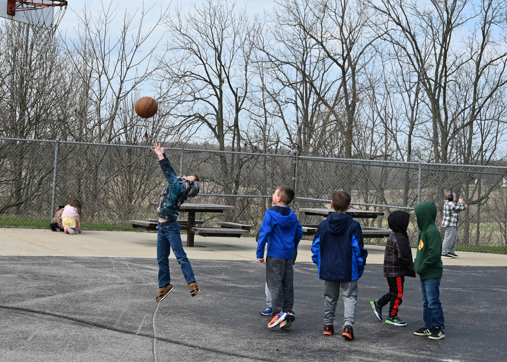 boys playing basketball on playground