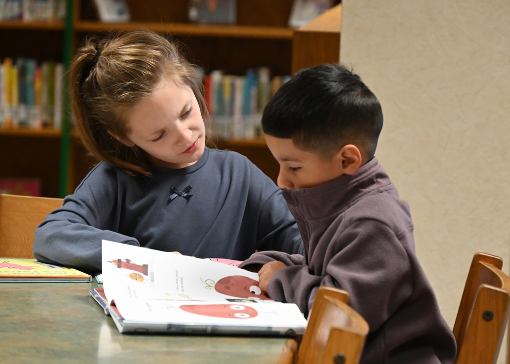 two childern looking at a book together