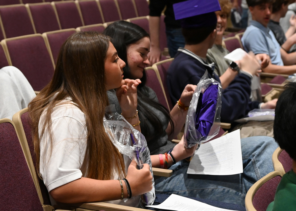 Students sitting in auditorium with packages