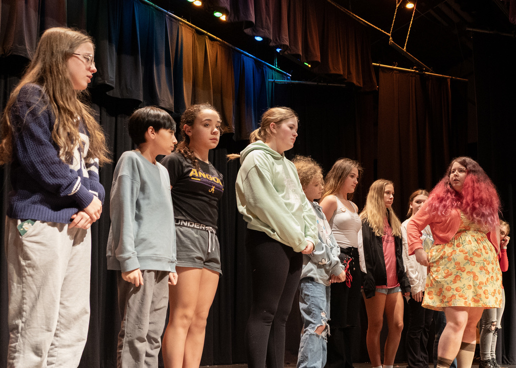 people in a line with one slightly in front looking back at the rest