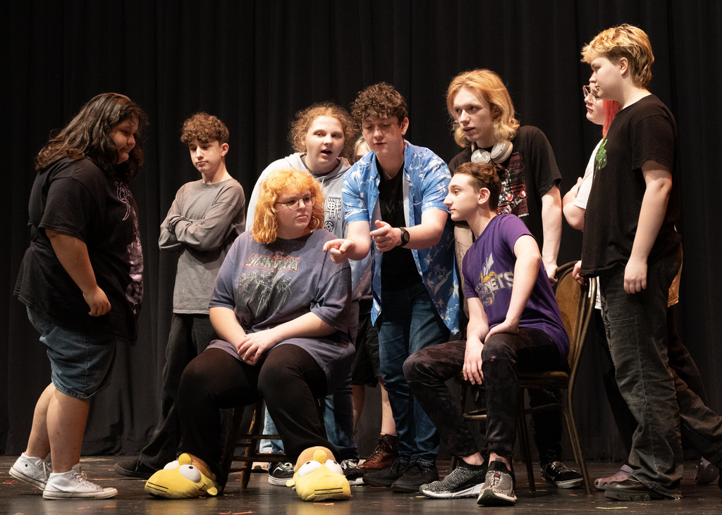 people gatherer around someone pretending to hold a paper