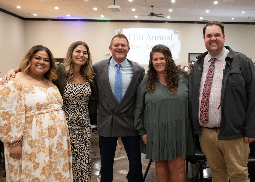 5 people standing in line posing for photo