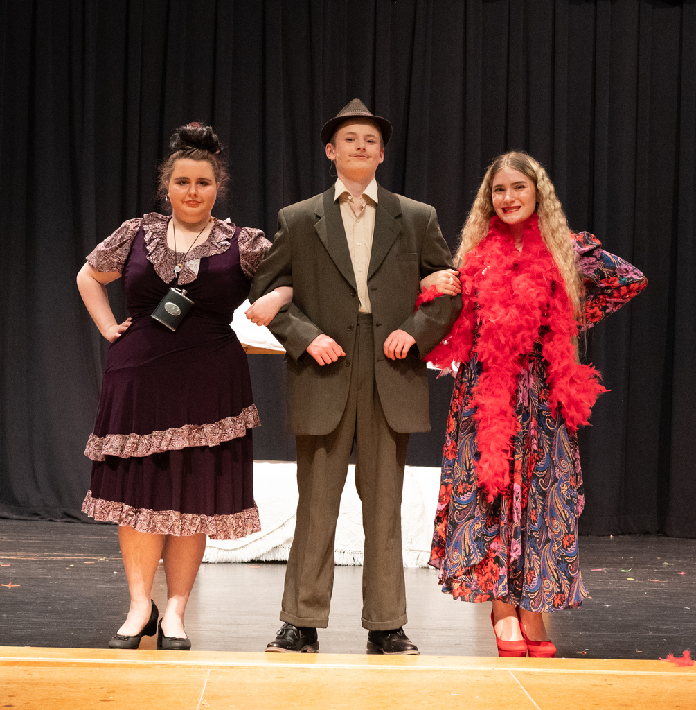 3 people in line dressed in costumes of the 30's