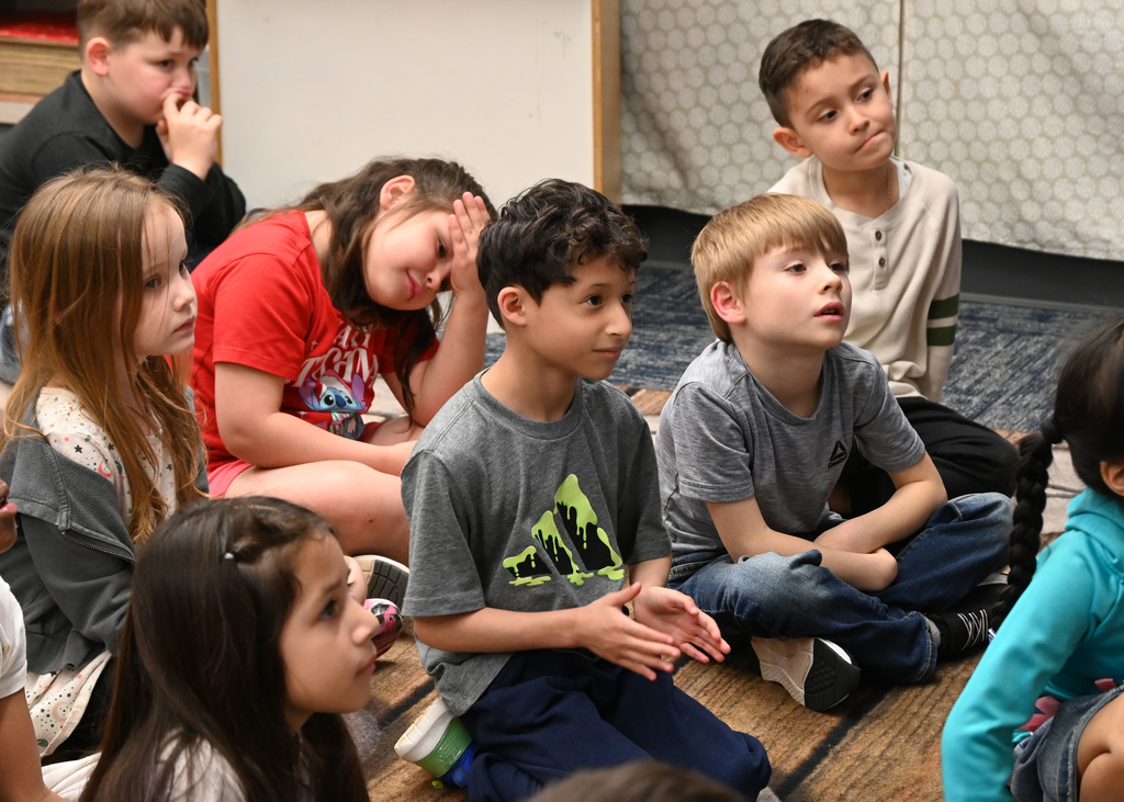 Childern sitting on floor listening to story
