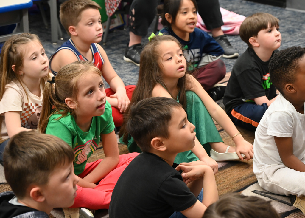 Childern sitting on floor listening to story 