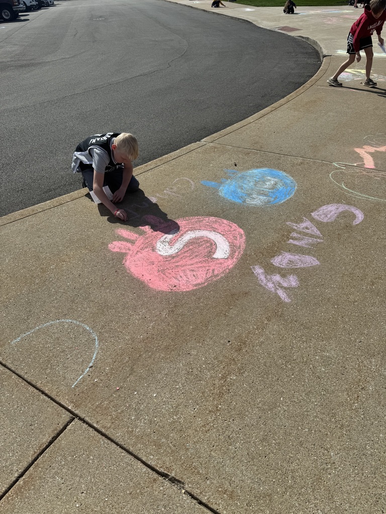 child kneeling in from of chalk drawing