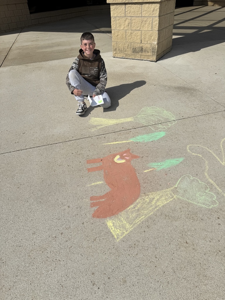 boy kneeling in from of chalk drawing