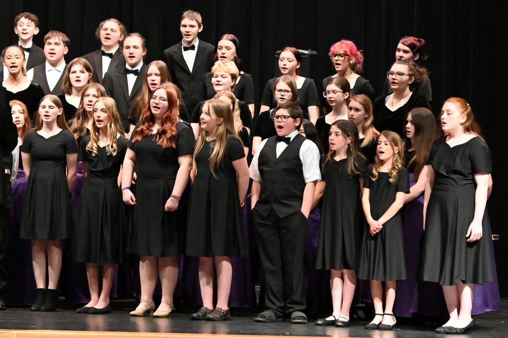 choir of girl and boys dressed in black singing