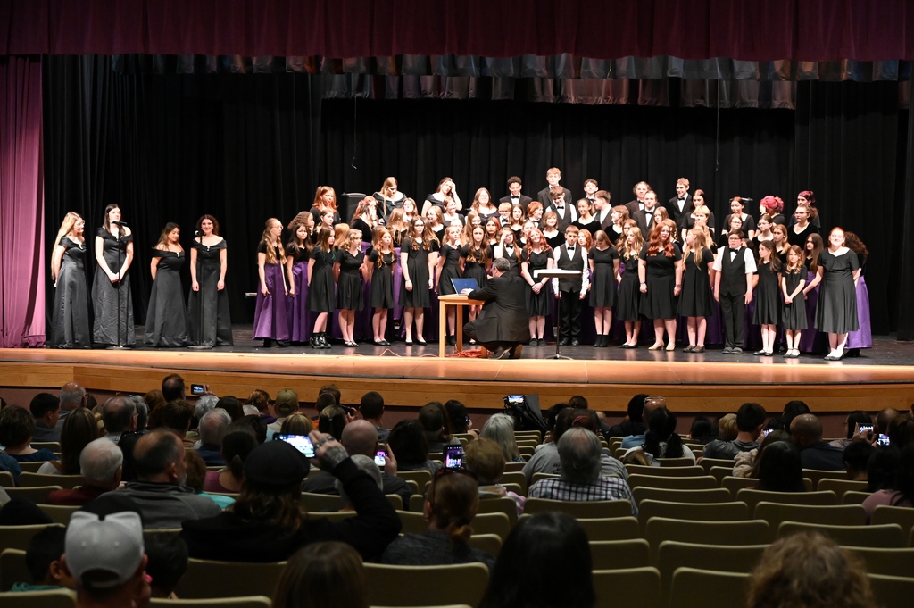 large choir of girl and boys dressed in black singing