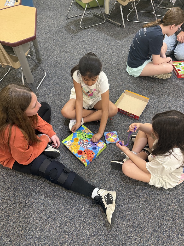 3 children sitting on floor playing board game