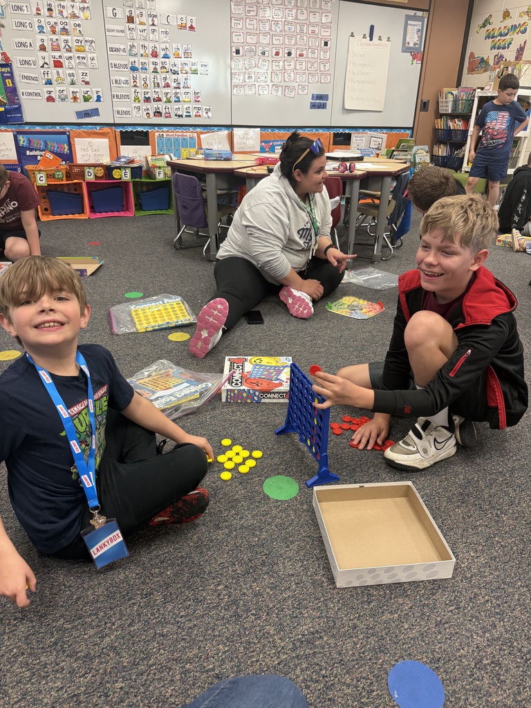 two students on floor playing board game