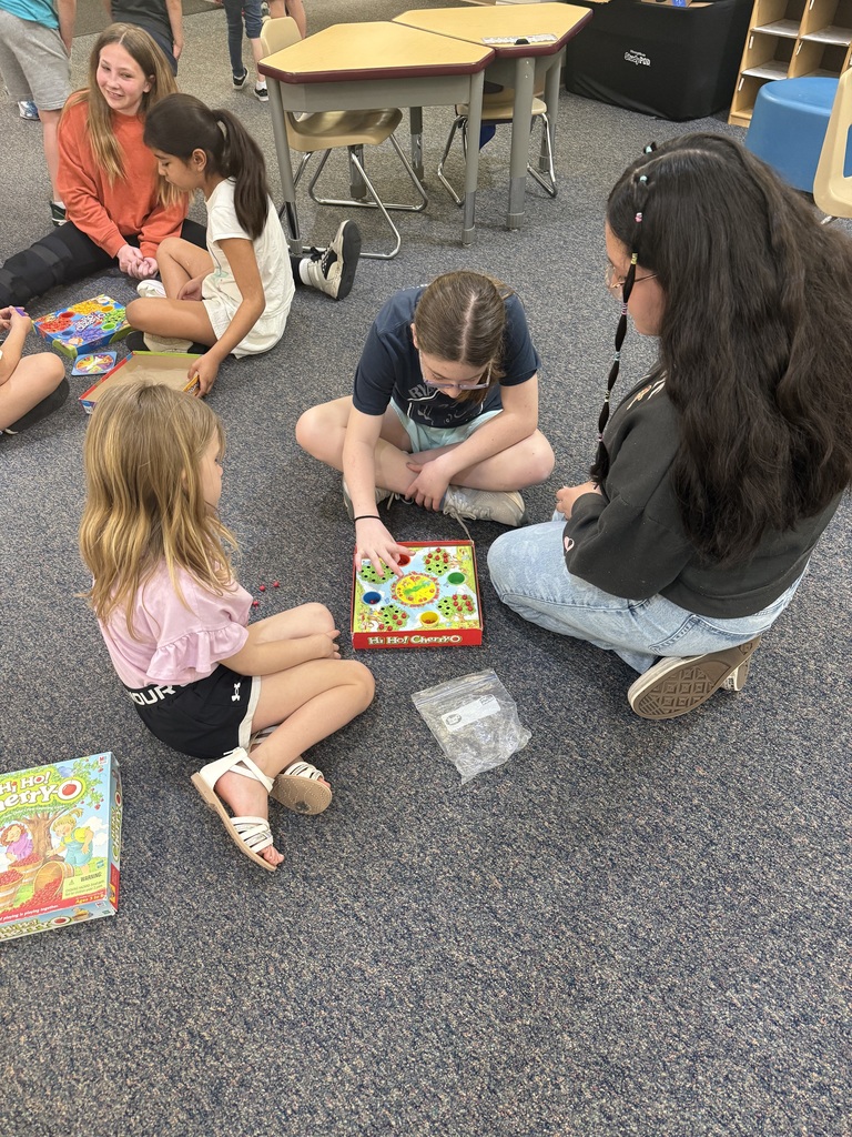 3 children sitting on floor playing board game