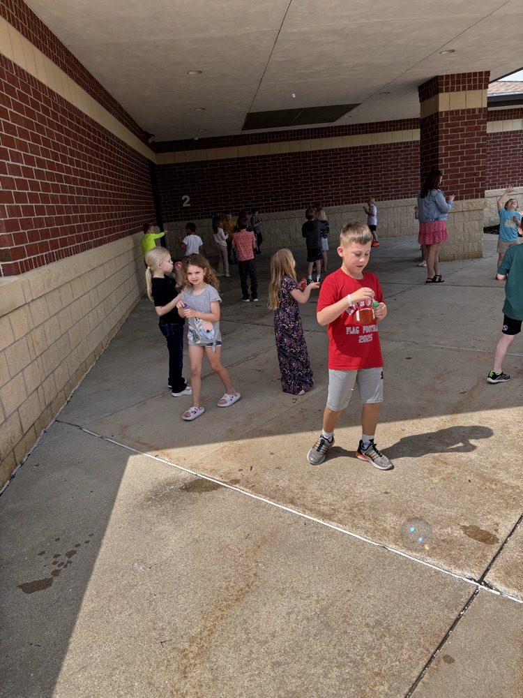 Children blowing bubbles outsited