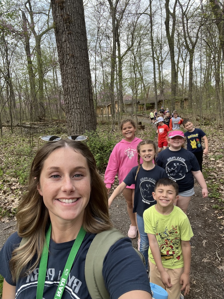 selfie of teacher leading a line of students on a trail outside