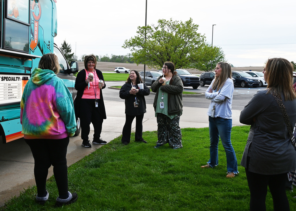 six people standing in front of coffee truck smiling