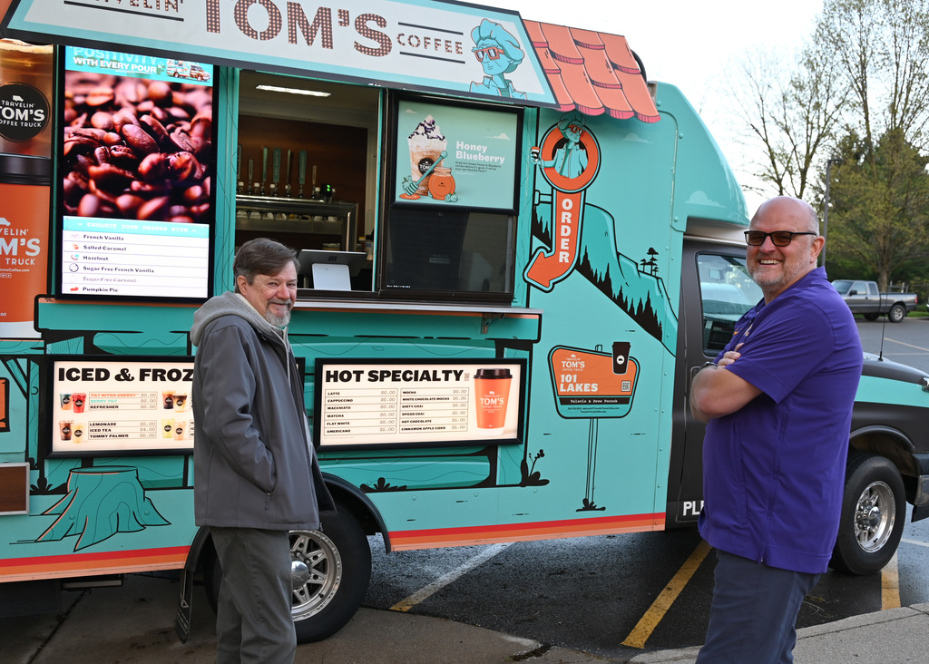 two men in front of coffee truck smiling