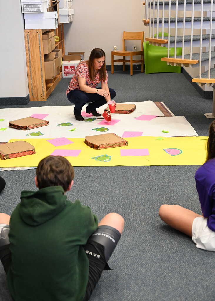 Teacher squatting down checking cup