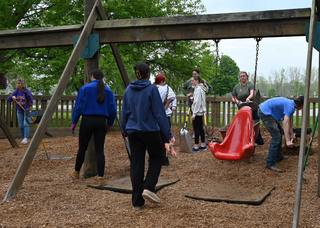 8 people spreading mulch at a playground