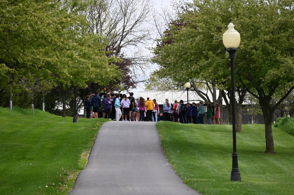 a large group of middle school students standig on top of path on a hill